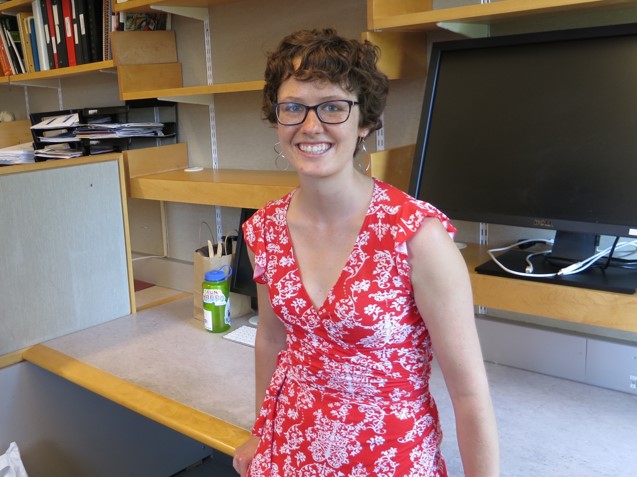 At my empty desk before my PhD graduation. My work is entirely computational, so no lab coat necessary!